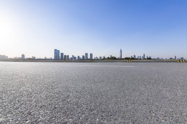 Panoramik siluet ve boş yolu, boş beton zemini olan modern iş binaları.