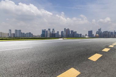 Panoramik siluet ve boş yolu, boş beton zemini olan modern iş binaları.