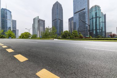 Panoramik siluet ve boş yolu, boş beton zemini olan modern iş binaları.