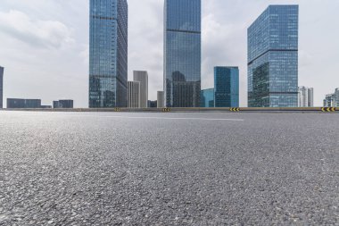 Panoramik siluet ve boş yolu, boş beton zemini olan modern iş binaları.