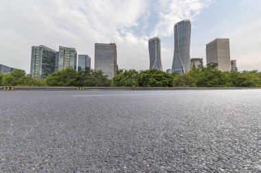 Panoramik siluet ve boş yolu, boş beton zemini olan modern iş binaları.