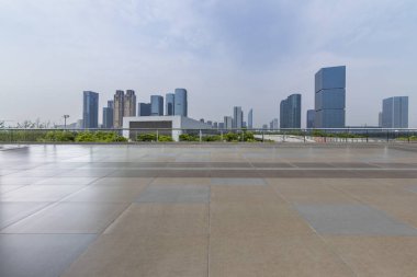 Panoramik siluet ve boş yolu, boş beton zemini olan modern iş binaları.