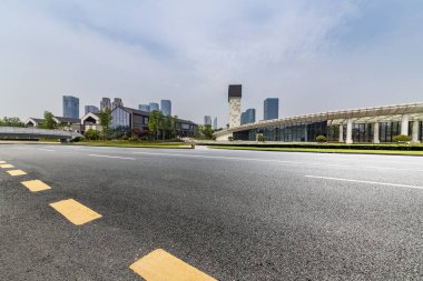 Panoramik siluet ve boş yolu, boş beton zemini olan modern iş binaları.