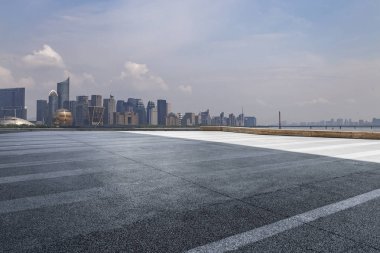 Panoramik siluet ve boş yolu, boş beton zemini olan modern iş binaları.