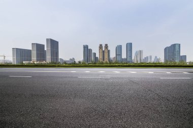 Panoramik siluet ve boş yolu, boş beton zemini olan modern iş binaları.