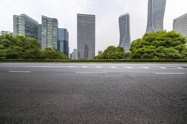 Panoramik siluet ve boş yolu, boş beton zemini olan modern iş binaları.