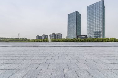 Panoramik siluet ve boş yolu, boş beton zemini olan modern iş binaları.