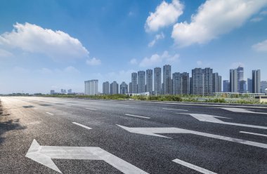 Panoramik siluet ve boş yolu, boş beton zemini olan modern iş binaları.