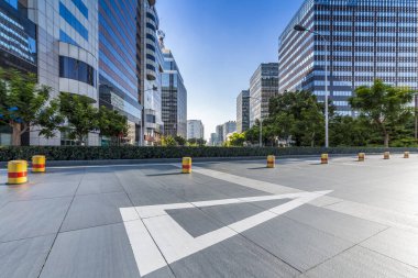 Panoramik siluet ve boş yolu, boş beton zemini olan modern iş binaları.
