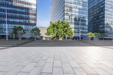 Panoramik siluet ve boş yolu, boş beton zemini olan modern iş binaları.