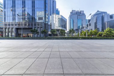 Panoramik siluet ve boş yolu, boş beton zemini olan modern iş binaları.