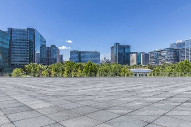 Panoramik siluet ve boş yolu, boş beton zemini olan modern iş binaları.