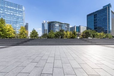 Panoramik siluet ve boş yolu, boş beton zemini olan modern iş binaları.