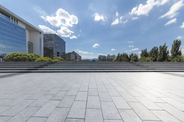 Panoramik siluet ve boş yolu, boş beton zemini olan modern iş binaları.