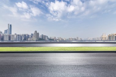 Panoramik siluet ve boş yolu, boş beton zemini olan modern iş binaları.