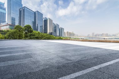 Panoramik siluet ve boş yolu, boş beton zemini olan modern iş binaları.