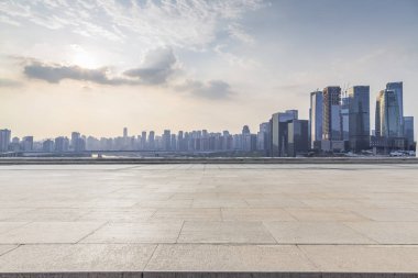 Panoramik siluet ve boş yolu, boş beton zemini olan modern iş binaları.