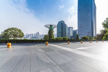 Panoramik siluet ve boş yolu, boş beton zemini olan modern iş binaları.