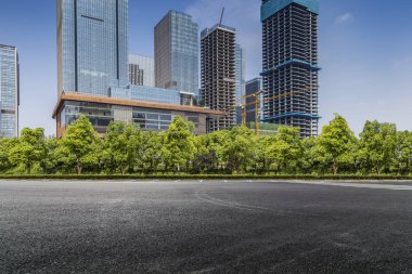Panoramik siluet ve boş yolu, boş beton zemini olan modern iş binaları.