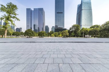 Panoramik siluet ve boş yolu, boş beton zemini olan modern iş binaları.