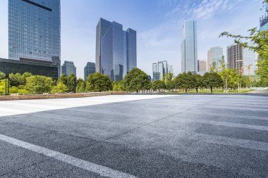 Panoramik siluet ve boş yolu, boş beton zemini olan modern iş binaları.