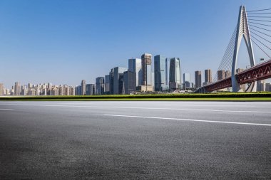 Panoramik siluet ve boş yolu, boş beton zemini olan modern iş binaları.