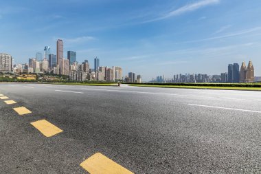 Panoramik siluet ve boş yolu, boş beton zemini olan modern iş binaları.