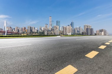 Panoramik siluet ve boş yolu, boş beton zemini olan modern iş binaları.