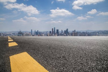 Panoramik siluet ve boş yolu, boş beton zemini olan modern iş binaları.