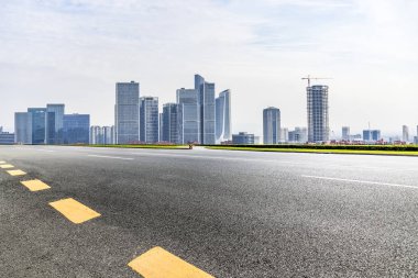 Panoramik siluet ve boş yolu, boş beton zemini olan modern iş binaları.