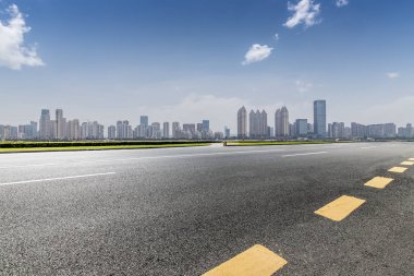 Panoramik siluet ve boş yolu, boş beton zemini olan modern iş binaları.
