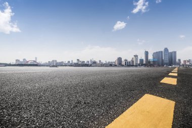 Panoramik siluet ve boş yolu, boş beton zemini olan modern iş binaları.