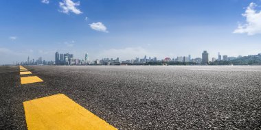 Panoramik siluet ve boş yolu, boş beton zemini olan modern iş binaları.