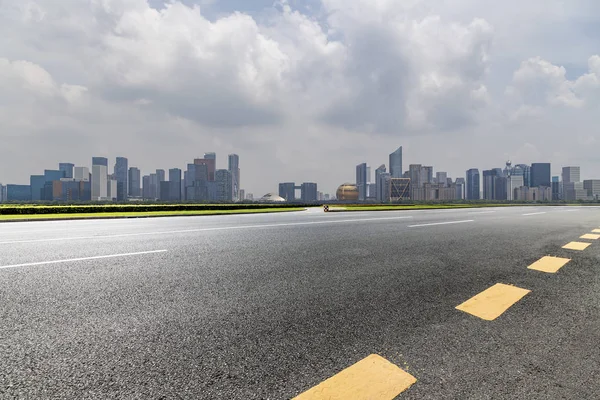 Panoramik siluet ve boş yolu, boş beton zemini olan modern iş binaları.