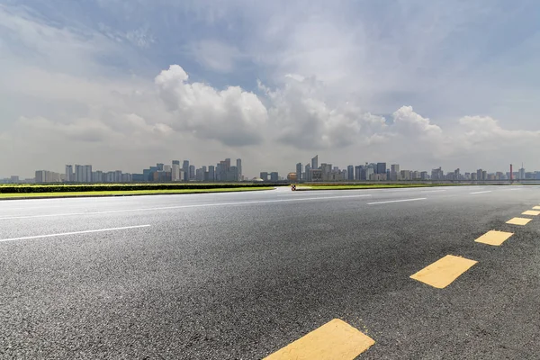 Panoramik siluet ve boş yolu, boş beton zemini olan modern iş binaları.