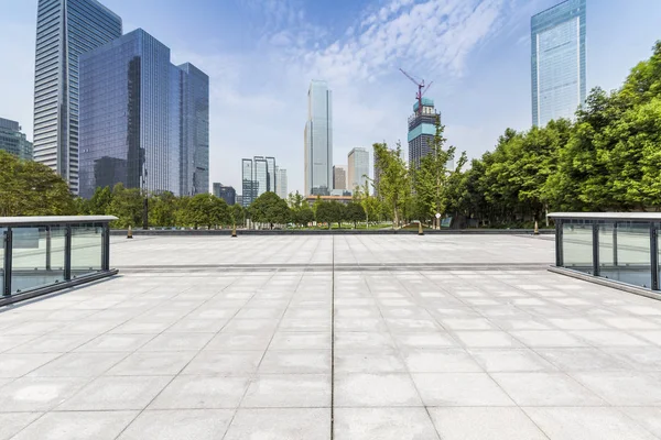 Panoramik siluet ve boş yolu, boş beton zemini olan modern iş binaları.