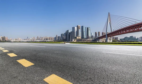 Panoramik siluet ve boş yolu, boş beton zemini olan modern iş binaları.