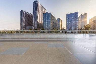 Panoramik siluet ve boş yolu, boş beton zemini olan modern iş binaları.