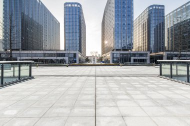 Panoramik siluet ve boş yolu, boş beton zemini olan modern iş binaları.