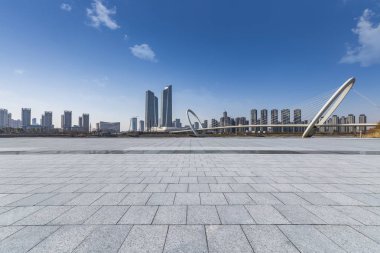 Panoramik siluet ve boş yolu, boş beton zemini olan modern iş binaları.