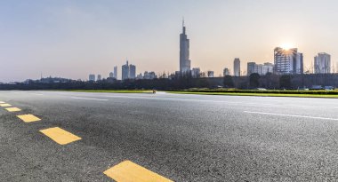 Panoramik siluet ve boş yolu, boş beton zemini olan modern iş binaları.