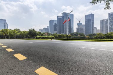 Panoramik siluet ve boş yolu, boş beton zemini olan modern iş binaları.