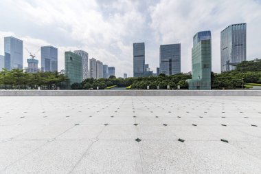 Panoramik siluet ve boş yolu, boş beton zemini olan modern iş binaları.