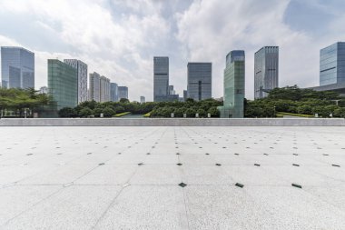 Panoramik siluet ve boş yolu, boş beton zemini olan modern iş binaları.