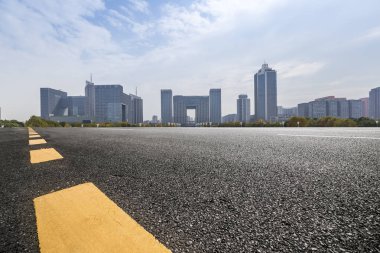 Panoramik siluet ve boş yolu, boş beton zemini olan modern iş binaları.