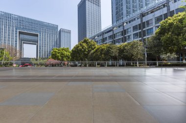 Panoramik siluet ve boş yolu, boş beton zemini olan modern iş binaları.