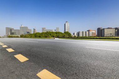 Panoramik siluet ve boş yolu, boş beton zemini olan modern iş binaları.