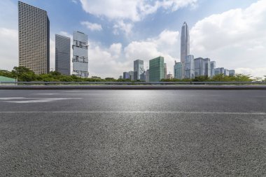 Panoramik siluet ve boş yolu, boş beton zemini olan modern iş binaları.