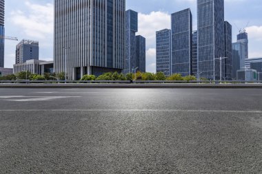 Panoramik siluet ve boş yolu, boş beton zemini olan modern iş binaları.