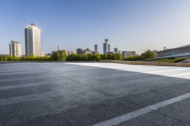 Panoramik siluet ve boş yolu, boş beton zemini olan modern iş binaları.